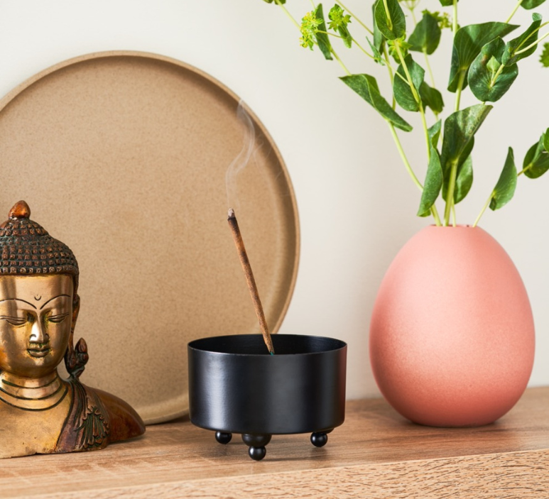 Best selling handmade incense sticks from Temple of Incense burning in a peaceful home with Buddha statue and soft light